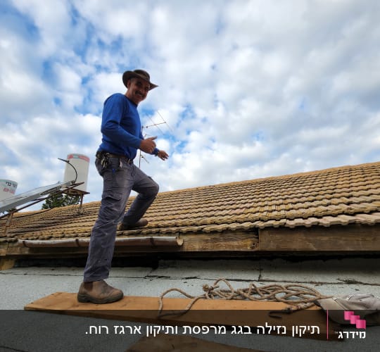 אדם עומד על גג רעפים עם קרשים וחבלים